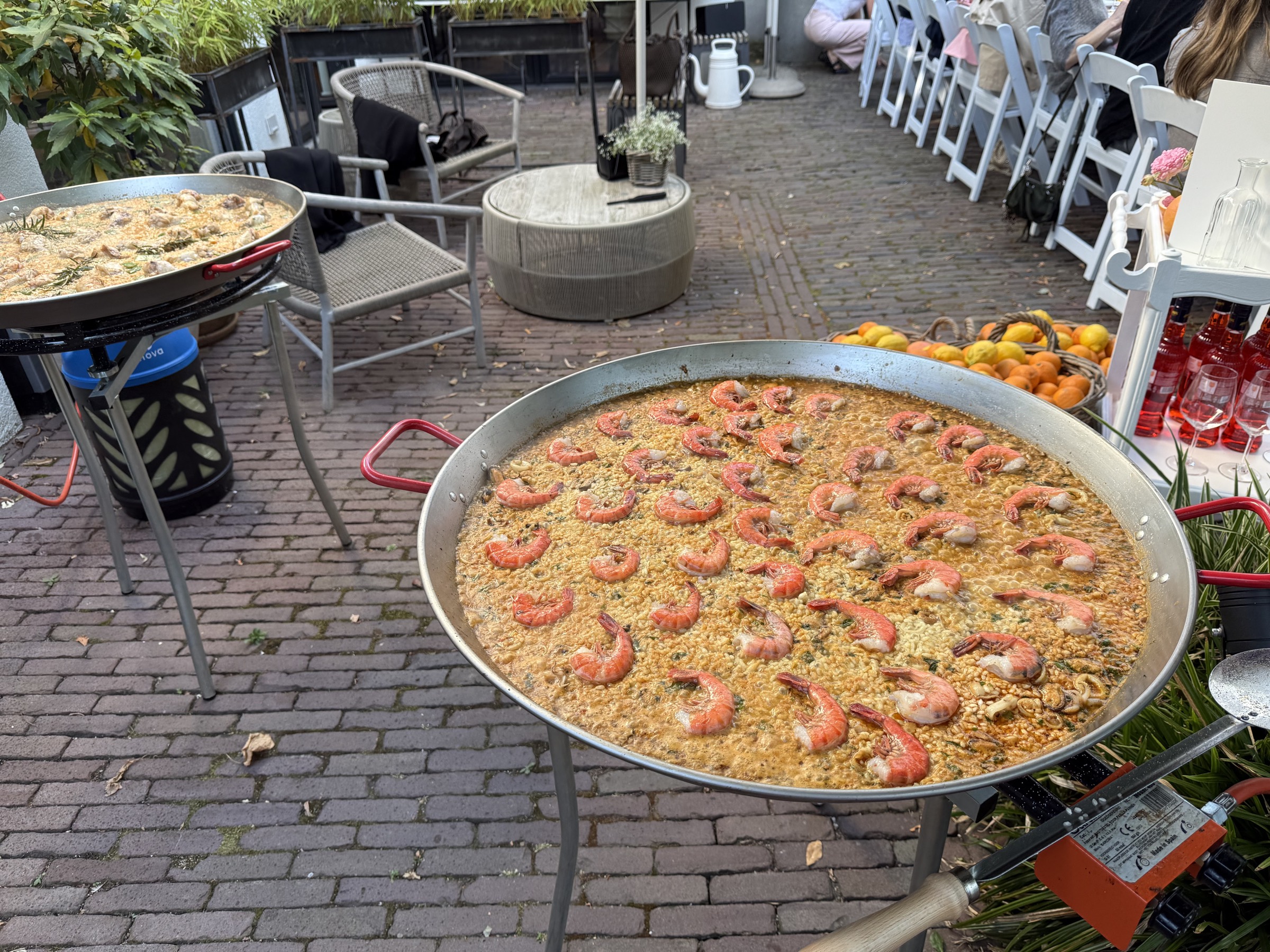 Grote paellapan met gamba's op een terras